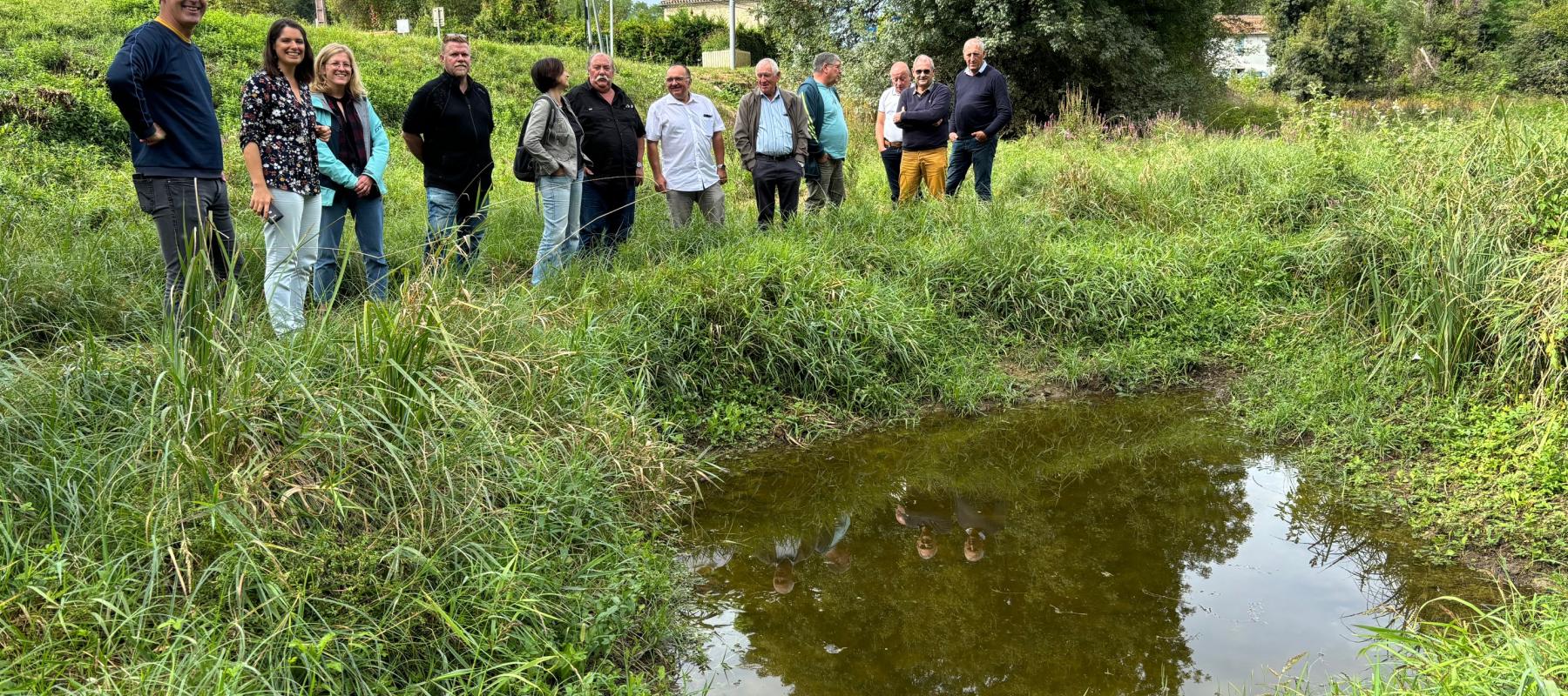 Visite de site avec les membres du COPIL devant une mare creusée grâce à un contrat Natura 2000 dans la prairie humide de Gueyze (47)